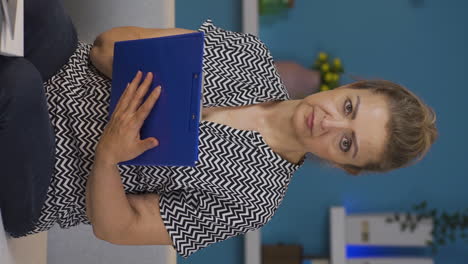 Vertical-video-of-Home-office-worker-woman-looking-dull-at-camera.